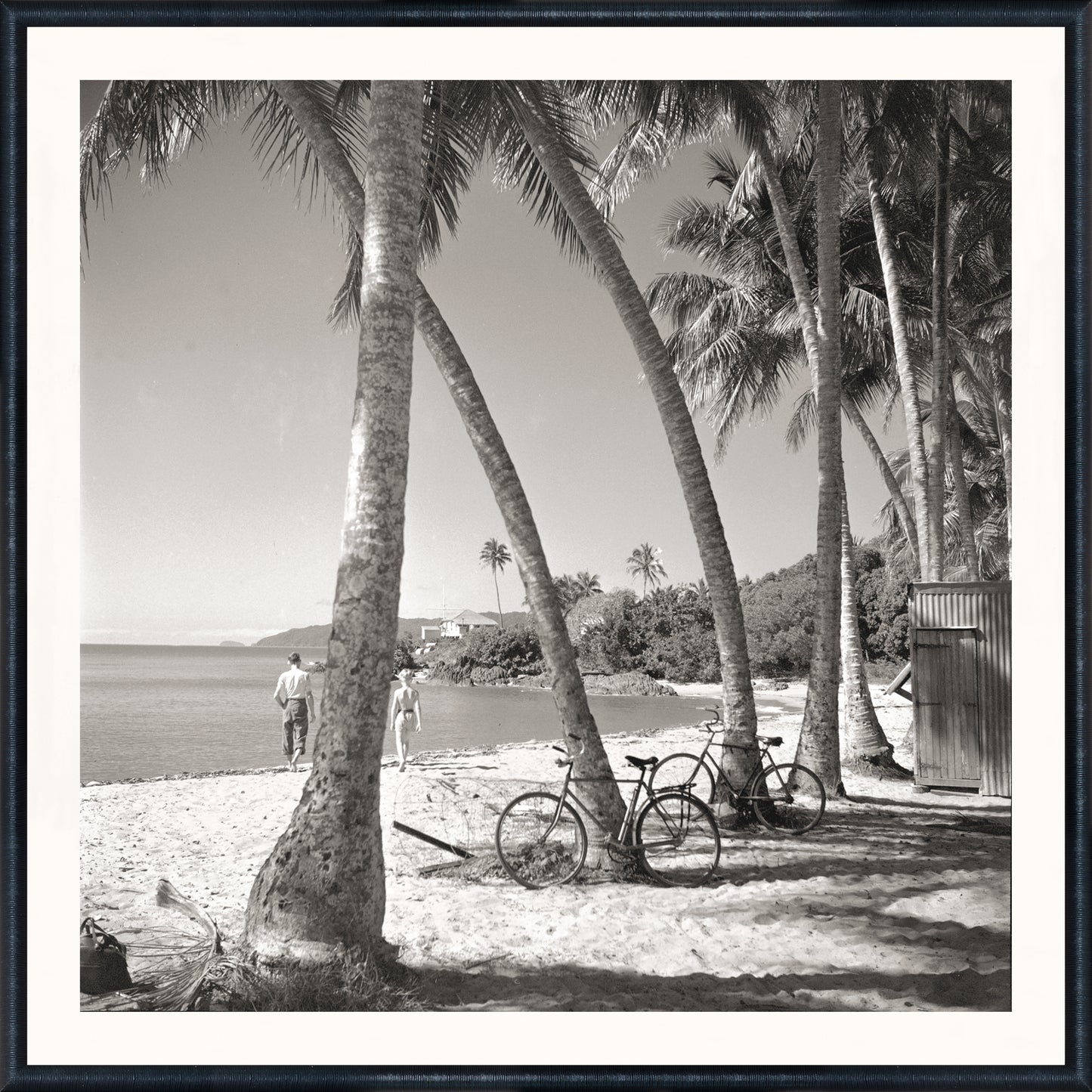 Black-and-white coastal photograph of a beach scene with palm trees, bicycles, and beachgoers at Mastry’s Art Shop in St. Petersburg, Florida