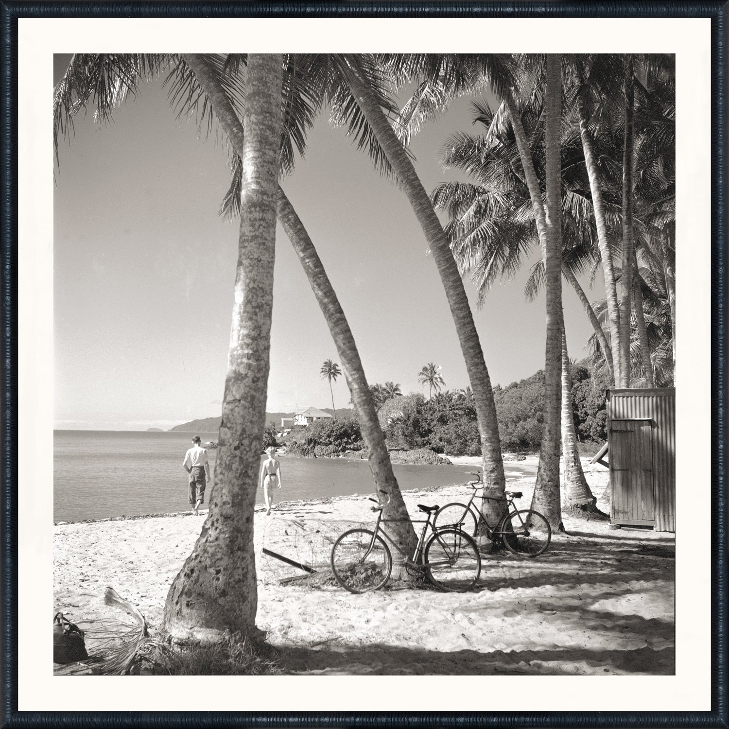 Black-and-white coastal photograph of a beach scene with palm trees, bicycles, and beachgoers at Mastry’s Art Shop in St. Petersburg, Florida